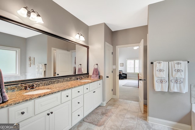 full bathroom featuring double vanity, baseboards, a sink, and marble finish floor