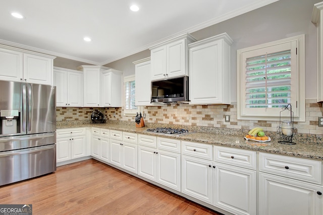 kitchen featuring tasteful backsplash, stainless steel appliances, and white cabinets