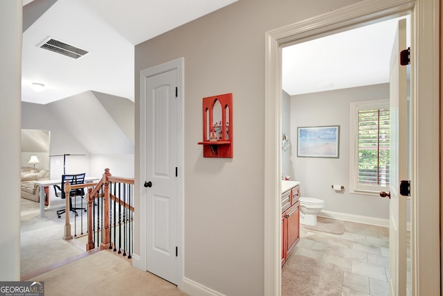 corridor featuring baseboards, an upstairs landing, stone finish flooring, and visible vents