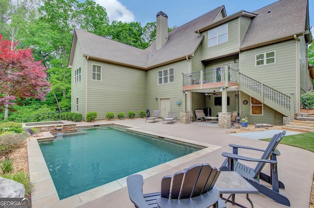 view of swimming pool with a patio, a pool with connected hot tub, and stairway