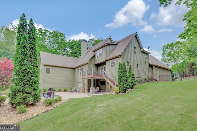 back of property featuring fence, a patio, a chimney, a yard, and stairway