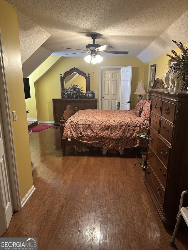 bedroom featuring wood finished floors, a ceiling fan, a textured ceiling, and lofted ceiling
