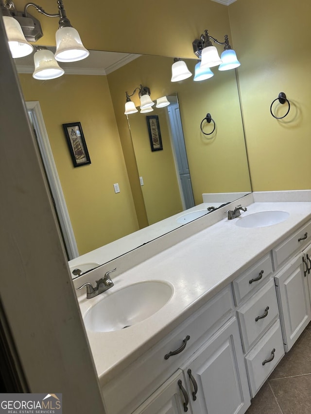 bathroom with tile patterned flooring, a sink, double vanity, and ornamental molding