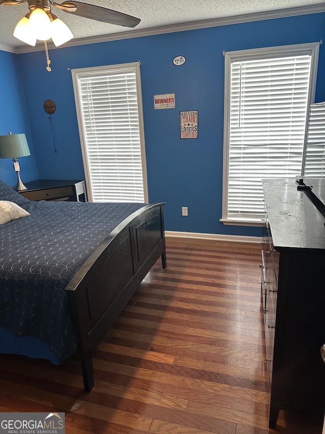 bedroom featuring baseboards, dark wood-style floors, ornamental molding, and ceiling fan