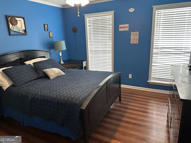 bedroom with baseboards, ornamental molding, and wood-type flooring