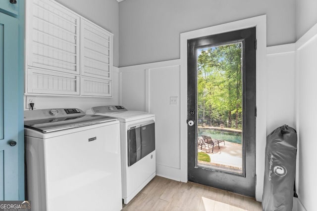 laundry room with separate washer and dryer, laundry area, and light wood-type flooring