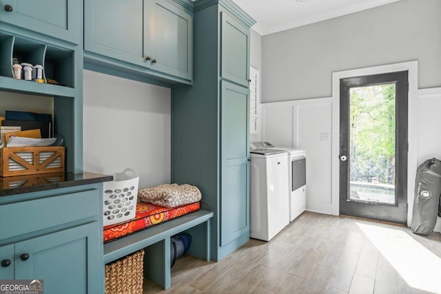 clothes washing area featuring cabinet space, separate washer and dryer, and light wood-style floors