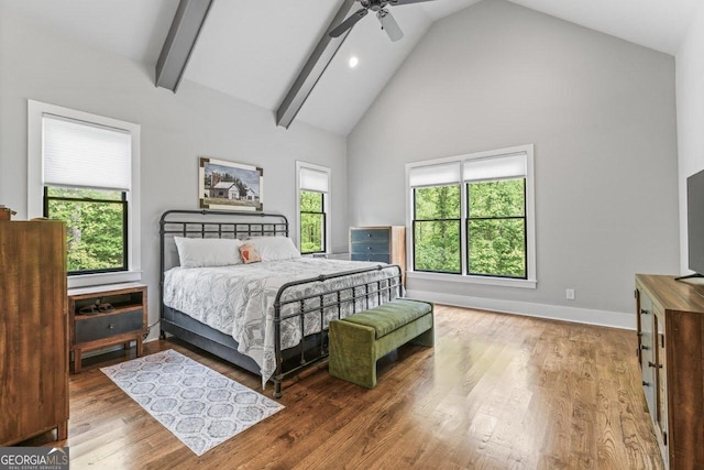 bedroom featuring beam ceiling, wood finished floors, baseboards, ceiling fan, and high vaulted ceiling