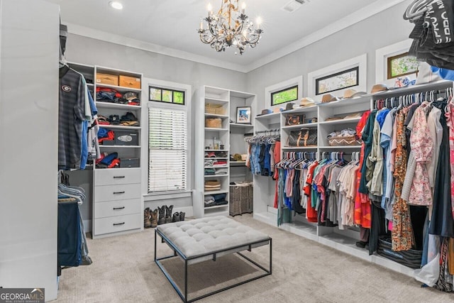 walk in closet featuring visible vents, carpet flooring, and a notable chandelier