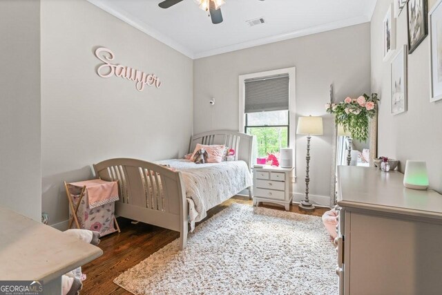 bedroom featuring crown molding, ceiling fan, wood finished floors, and visible vents