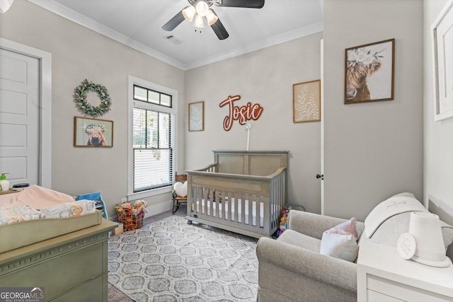 carpeted bedroom featuring crown molding, visible vents, baseboards, ceiling fan, and a nursery area
