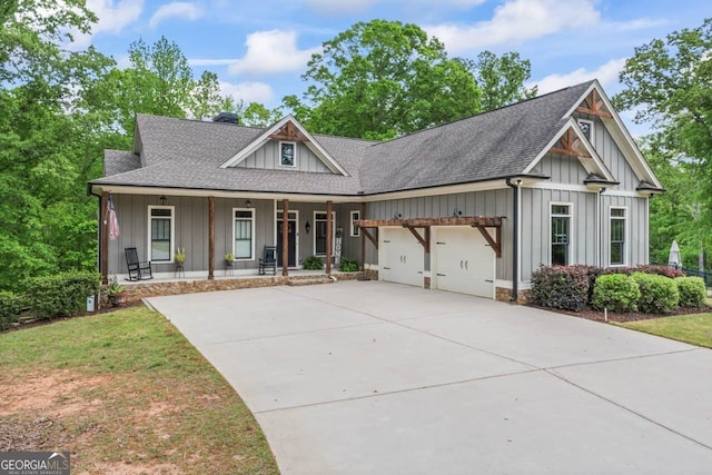 view of front of house with board and batten siding, a shingled roof, covered porch, and a garage