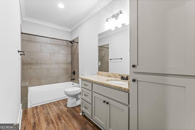 full bathroom featuring vanity, ornamental molding, wood finished floors, tub / shower combination, and toilet