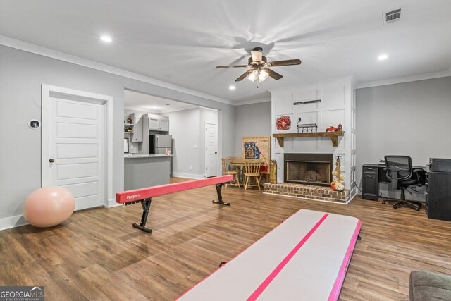 exercise room featuring recessed lighting, ornamental molding, a ceiling fan, and wood finished floors