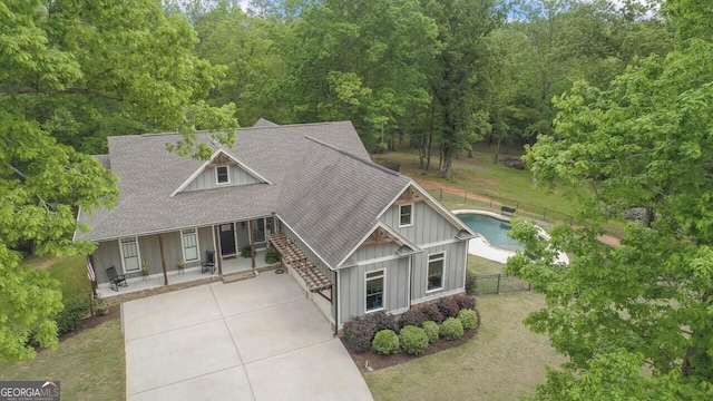 view of front of property featuring fence, stairs, a shingled roof, board and batten siding, and driveway