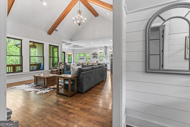 living room with beamed ceiling, high vaulted ceiling, an inviting chandelier, and wood finished floors