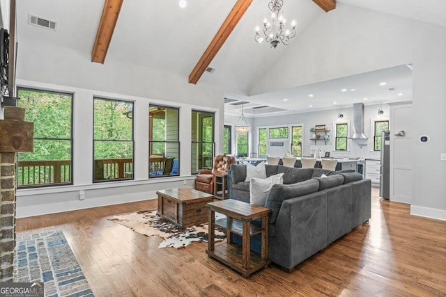 living area featuring high vaulted ceiling, a chandelier, wood finished floors, beamed ceiling, and visible vents