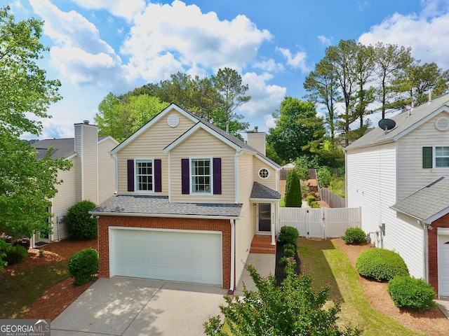 view of front of house with a gate, an attached garage, brick siding, and driveway