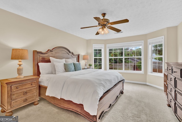 bedroom featuring baseboards, light carpet, visible vents, and a ceiling fan