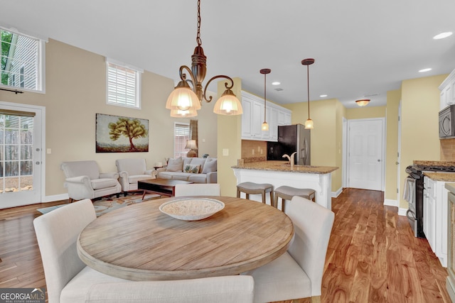 dining room featuring light wood-type flooring, baseboards, and recessed lighting