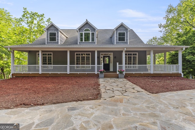 view of front of home featuring covered porch and a shingled roof