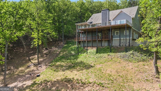 back of house featuring a wooden deck and a chimney