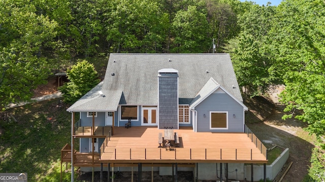 back of property with a chimney and a deck