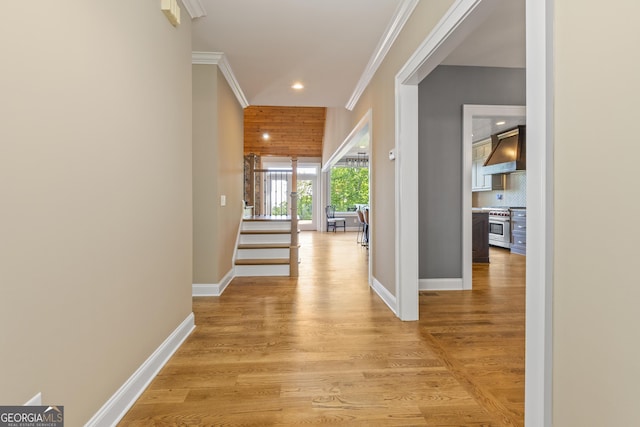 hallway featuring crown molding, recessed lighting, baseboards, and light wood-style floors