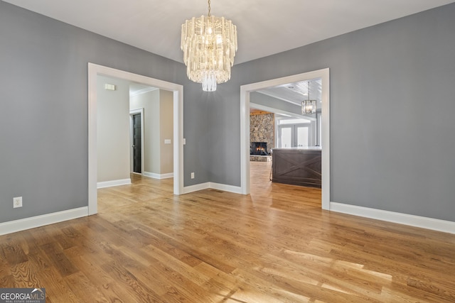 unfurnished dining area featuring light wood-style floors, baseboards, and a chandelier
