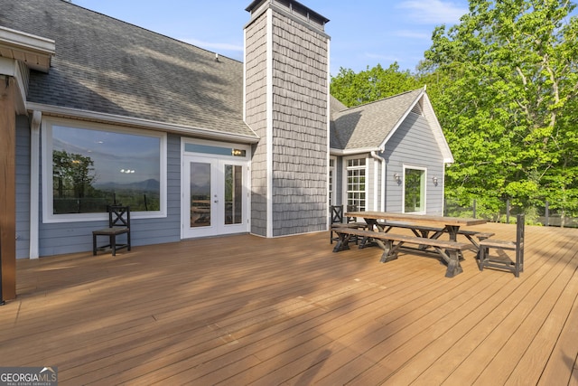 wooden terrace featuring french doors and outdoor dining space