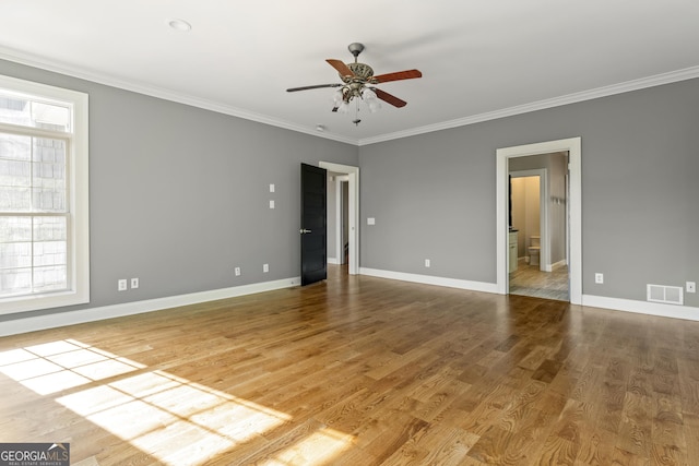 spare room featuring crown molding, baseboards, a ceiling fan, and visible vents