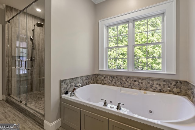 full bathroom with a whirlpool tub and a shower stall