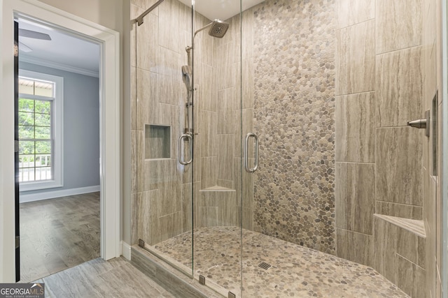 bathroom featuring crown molding, baseboards, and a shower stall