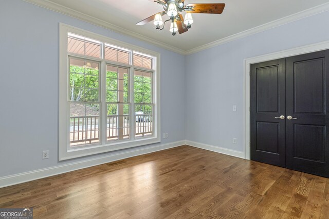 unfurnished bedroom with visible vents, dark wood finished floors, baseboards, a closet, and ornamental molding