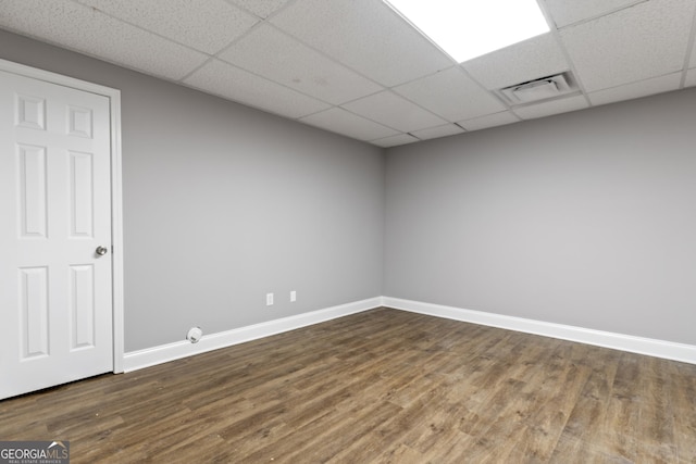 unfurnished room featuring visible vents, dark wood-style flooring, baseboards, and a drop ceiling