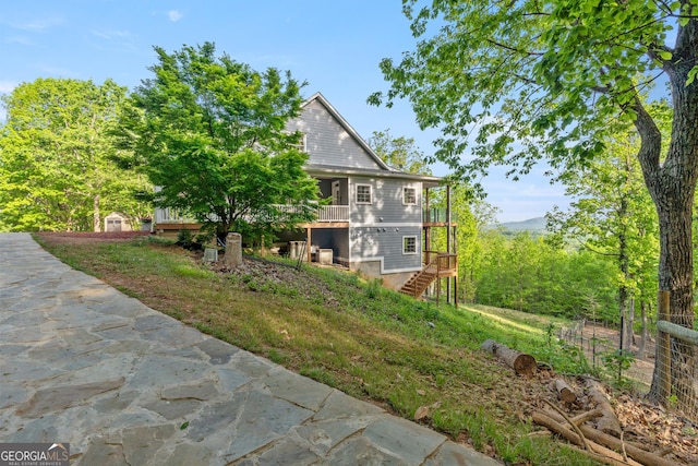 view of side of home with stairs and a wooden deck