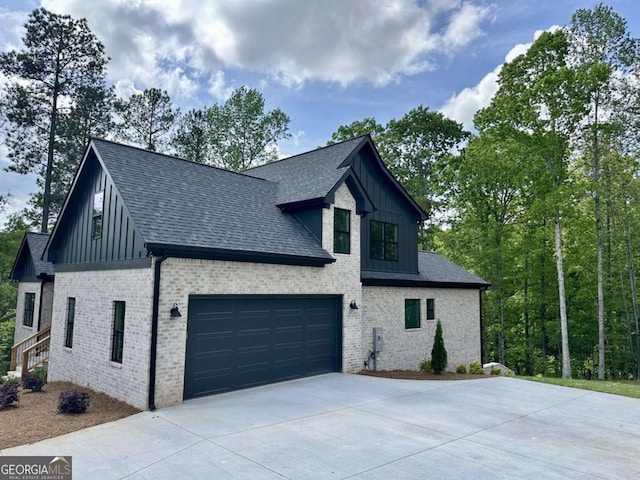 view of property exterior with a shingled roof, board and batten siding, driveway, and brick siding