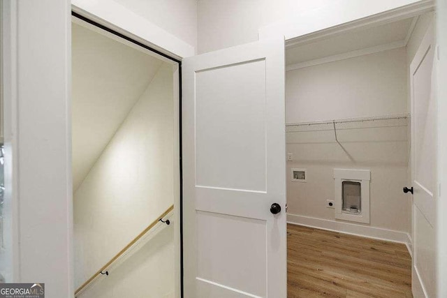 clothes washing area with laundry area, baseboards, hookup for a washing machine, electric dryer hookup, and light wood-style flooring