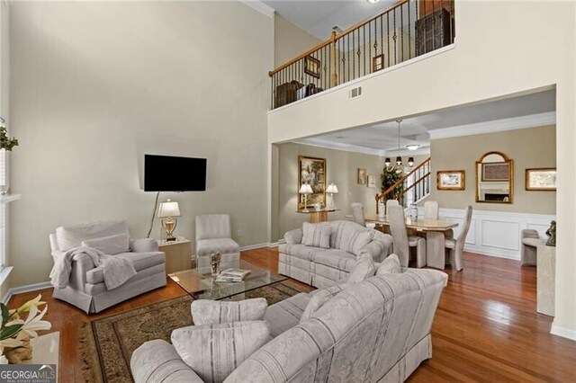 441 Mountain View Ln, Woodstock, GA 30188 - living room with crown molding, visible vents, stairs, wood finished floors, and a notable chandelier