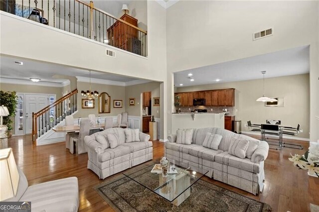441 Mountain View Ln, Woodstock, GA 30188 - living room with stairs, visible vents, wood finished floors, and an inviting chandelier