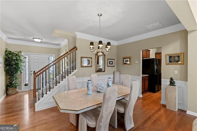 441 Mountain View Ln, Woodstock, GA 30188 - dining space featuring crown molding, stairs, light wood finished floors, and a notable chandelier