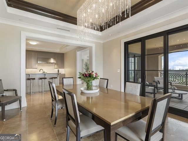 dining room featuring a tray ceiling, a chandelier, and ornamental molding