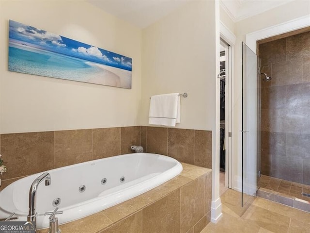 full bath with a whirlpool tub, a walk in closet, tile patterned floors, and a shower stall
