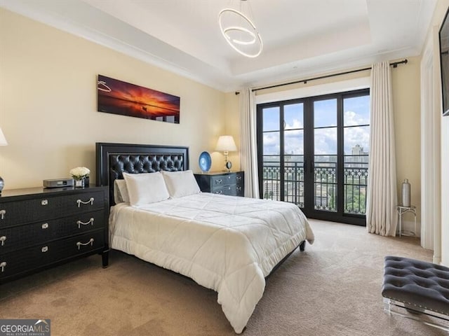 bedroom featuring carpet, a tray ceiling, and access to exterior