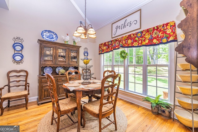 dining room with crown molding, a chandelier, light wood finished floors, baseboards, and a high ceiling