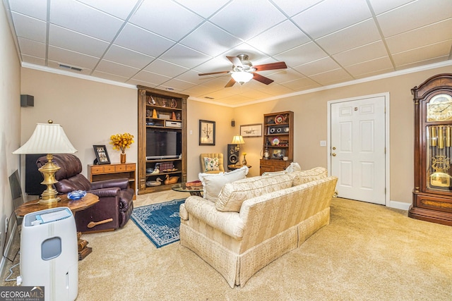 living room with carpet, ornamental molding, and ceiling fan