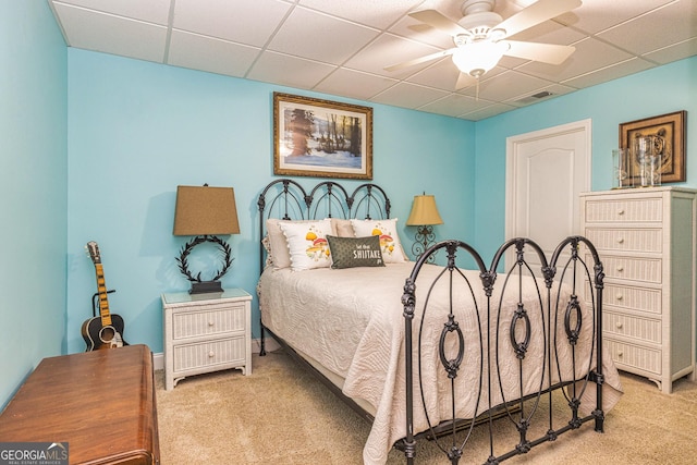 bedroom with carpet, a drop ceiling, and ceiling fan
