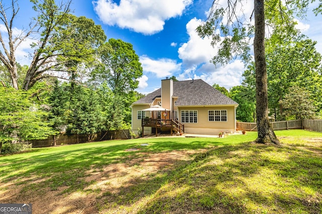 rear view of property featuring a chimney, a deck, stairs, and a shingled roof