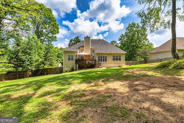 back of property with a chimney, a wooden deck, stairs, and roof with shingles