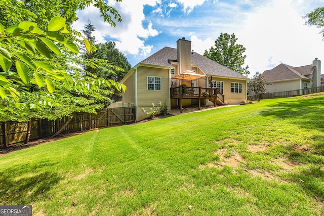 back of property with a wooden deck, a gazebo, a chimney, and a gate